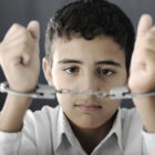 racial and ethnic bias: Kid with handcuffs on hands