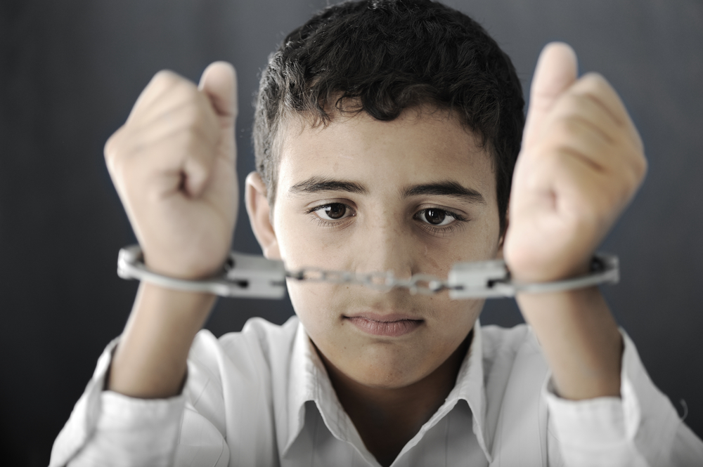 racial and ethnic bias: Kid with handcuffs on hands