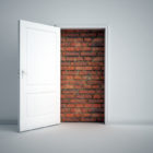 reentry: A brick wall blocking white doorway in white room