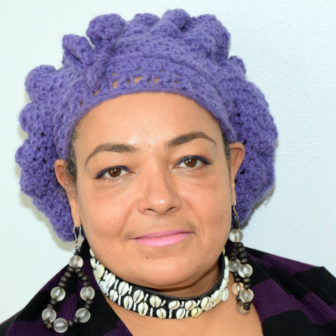 COVID-19: serious woman in lilac yarn hat, earrings, necklace, purple striped top