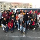 coronavirus: Group of young people holding coffee in front of van in parking lot