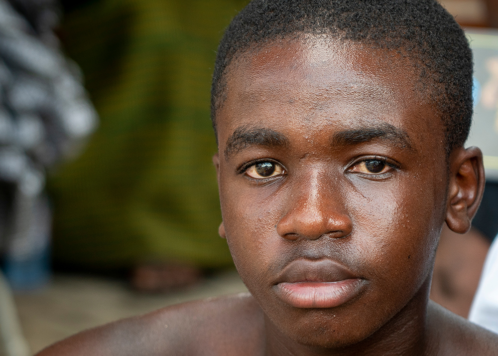 raise the age: Serious bare-chested young man stares at the camera