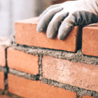 prison labor: Close-up of worker laying bricks on construction site