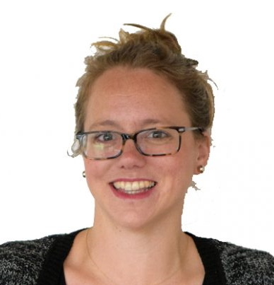 homeless shelter: smiling woman with short brown hair, glasses, earrings, black top, black cardigan