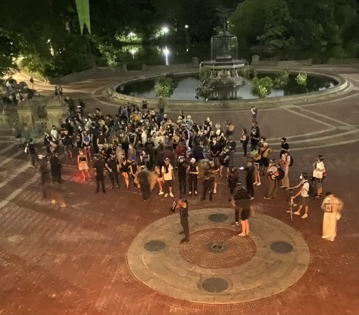 warrant squad: Overhead view of spread-out group of people outside near fountain at night