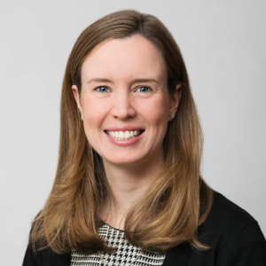 telehealth: Anne Marie McGrory (headshot), communications manager at Stoneleigh Foundation, smiling woman with light brown shoulder-length hair, earrings, black and white outfit
