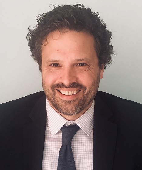 juvenile records: Andrew Keats (headshot), staff attorney at Juvenile Law Center, smiling man with short brown curly hair, light beard, mustache, wearing dark jacket, tie, checked shirt