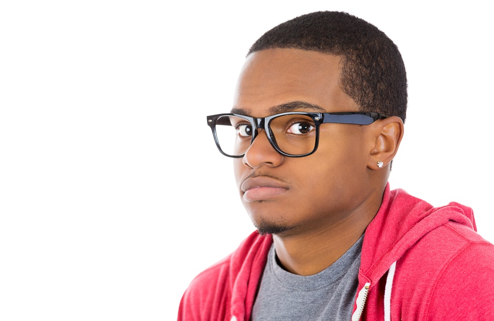 Closeup portrait of a young nerdy looking man with glasses, very timid, suspicious shy and anxious looking at camera