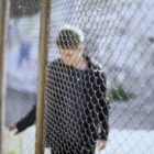 life sentence: Teen boy behind fence with bent head