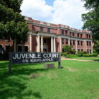Shakespeare: Low, large brick building with lawn; sign says Juvenile Court and address