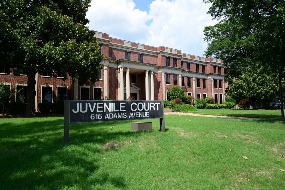 Shakespeare: Low, large brick building with lawn; sign says Juvenile Court and address
