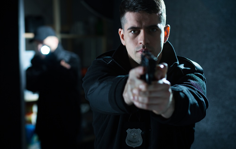 White policeman holding a handgun