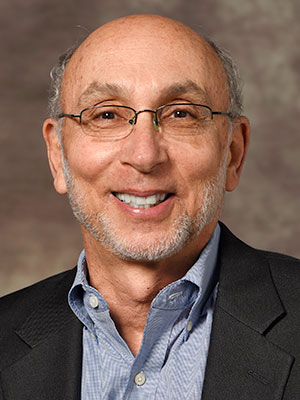 ead poisoning: Dr. Jeffrey L. Goldhagen headshot_smiling balding man with light gray hair, sideburns, beard, glasses, blue shirt, black jacket