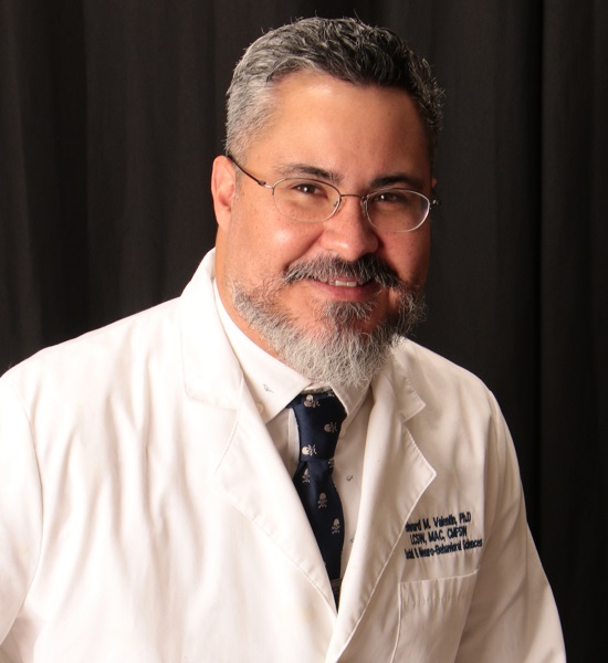 connection: Edward M. Valentin (headshot), clinical director of Families First, smiling man with gray hair, beard, mustache wearing lab coat over white shirt, tie