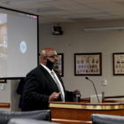 South Carolina's juvenile prisons director: Sitting wearing dark suit, white shirt and glasses, South Carolina Department of Juvenile Justice Director Freddie Pough testifies in front of state lawmakers in Columbia, S.C.
