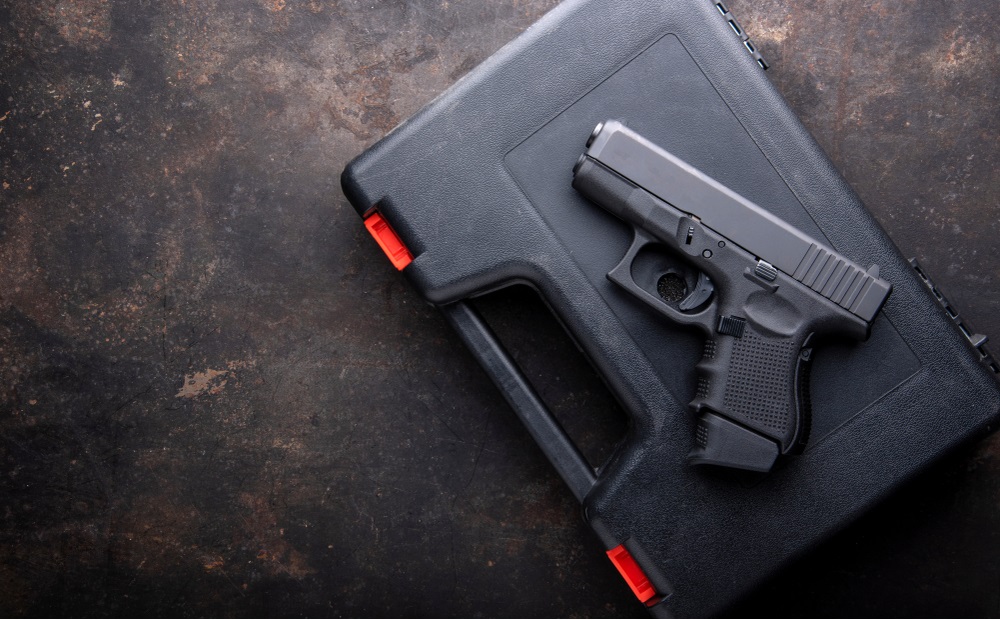 California gun owners living with youth study: Pistol, Gun over case for gun on dark metal table