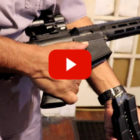 Savannah gun violence: close-up of male hands aiming a black, semi-automatic gun off-camera to right of image