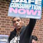 medical treatments for substance abuse in New York jails: woman holding "safe consumption now!" sign