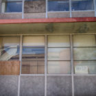 Juvenile reform: multiple metal-framed windows of abandoned multi-story building
