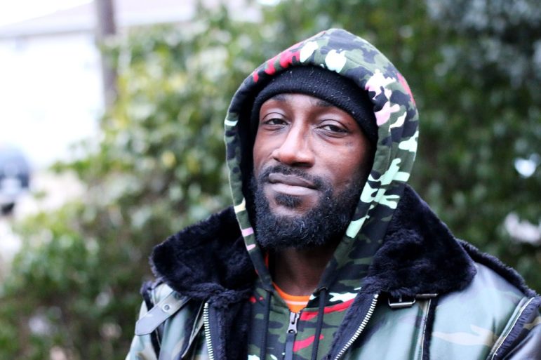 former Blood gang member charts a new course: Black man with beard in a camouflage hoodie