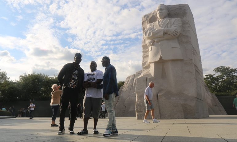 former Blood gang member charts a new course: three Black men stand in front of MLK Jr. monument