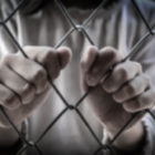 S.C. Juvenile Justice System lawsuit: Two hands intertwined with chain link fence close-up