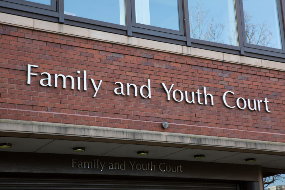 Teen court: Red brick building with closeup of sign in silver letters reading "Family and Youth Court""