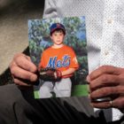 ghost gun rule: hands holding a picture of child in baseball uniform