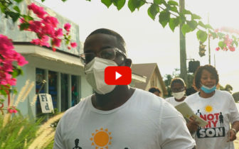 Gun Violence: Group of Black adults wearing masks with "Not My Don" t-shirts walk along city sidewalk
