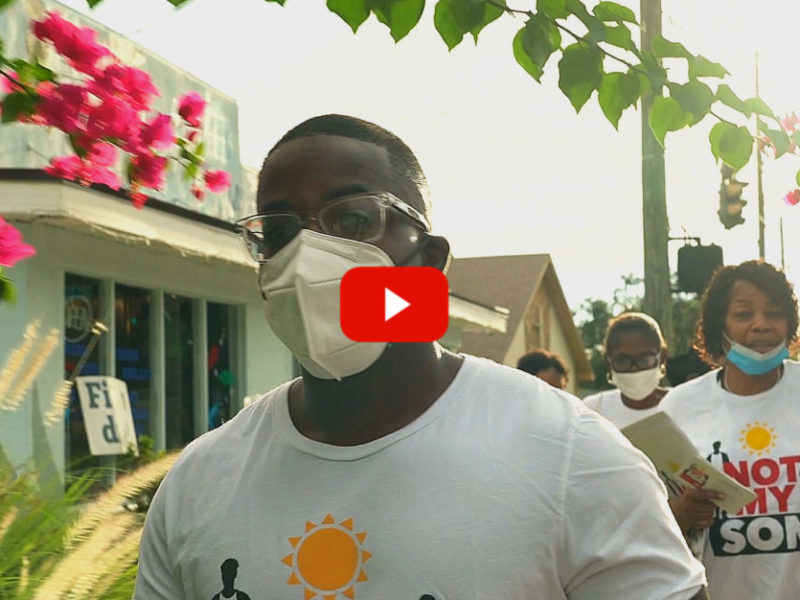 Gun Violence: Group of Black adults wearing masks with "Not My Don" t-shirts walk along city sidewalk