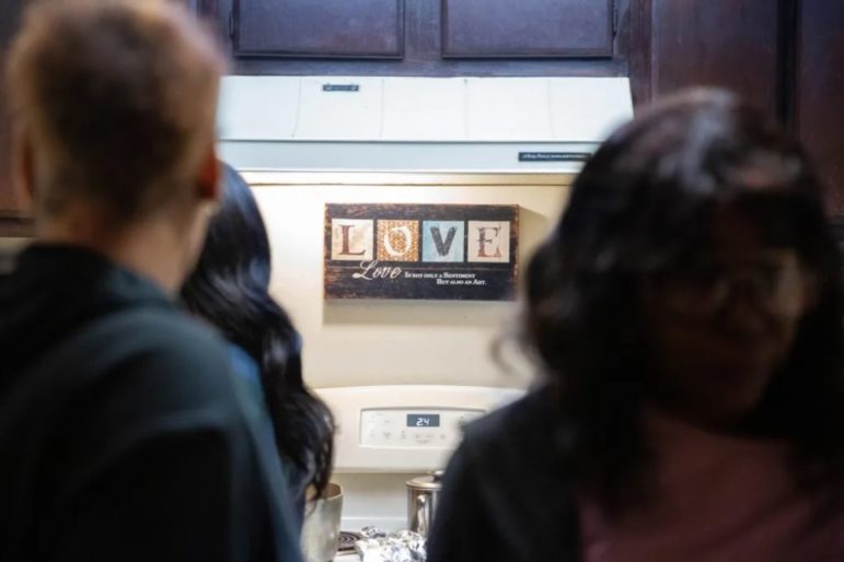 toll of his absence; women supporting prisoner Almeer Nance: love sign on wall above stove