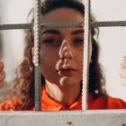 Girls in the juvenile justice system: girl looking through detention center bars