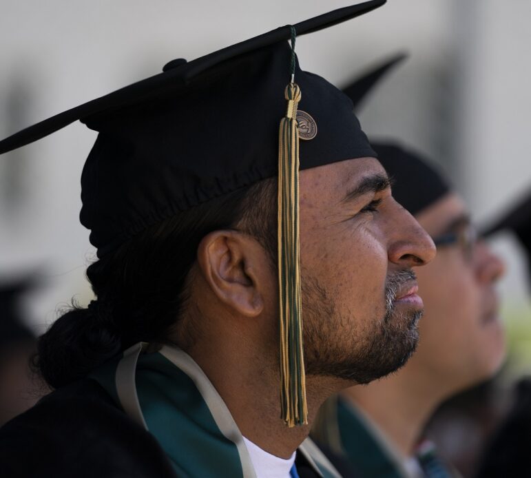 Free college for more prisoners: man in graduation cap looks up at something