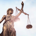 Legal Intershup: Statue of Lady Justice bronze statue holding Scales of justice and blue sky