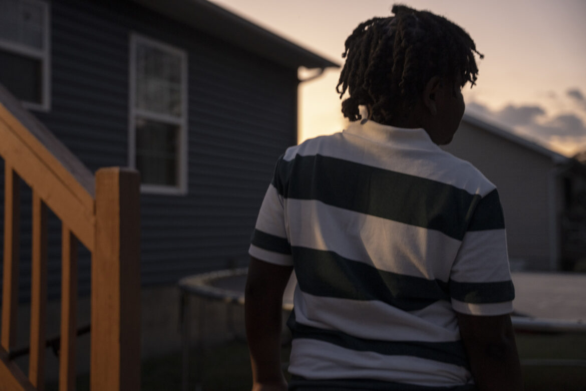 11-year old arrested for making threat in Tennessee: view of young black child form behind in horizontal striped shirt at dusk