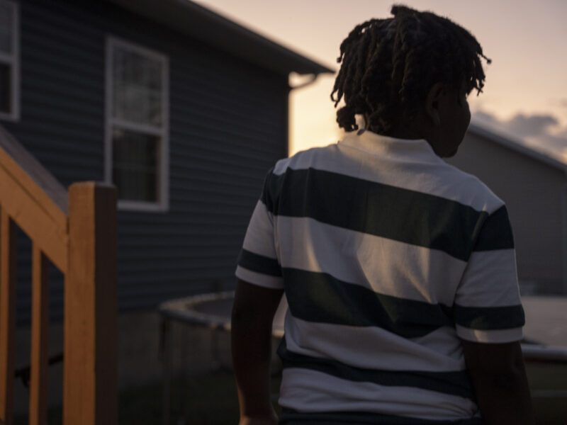 11-year old arrested for making threat in Tennessee: view of young black child form behind in horizontal striped shirt at dusk