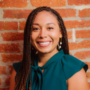 Restorative justice: headshot black woman with long black hair in forest green blouse