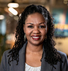 Restorative justice: headshot black woman with long black hair in gray suit and white blouse